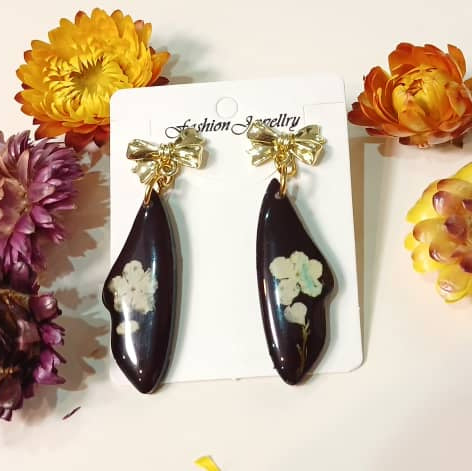 Handgefertigte Harzohrringe "Dunkle Eleganz" mit eingebetteten Blüten und Elemente in Goldoptik, hochwertiger Schmuck.
